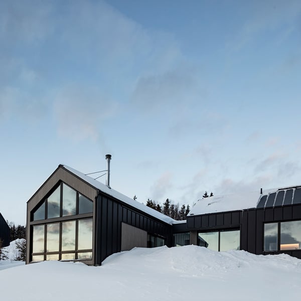 Un chalet bois rectangulaire sous la neige au Canada