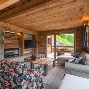 Un salon chaleureux en bois et pierre dans un chalet en bois