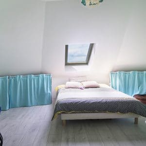 chambre des parents avec fenêtre dans une petite maison en bois